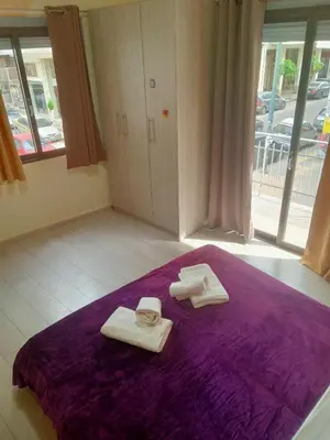 two towels on a purple bed in a room at Koukaki-Acropolis roomy with a private veranda apt. in Athens