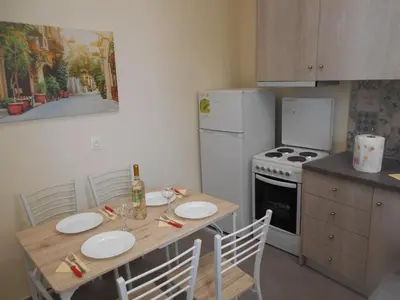 a kitchen with a wooden table and a white refrigerator at Koukaki-Acropolis roomy with a private veranda apt. in Athens