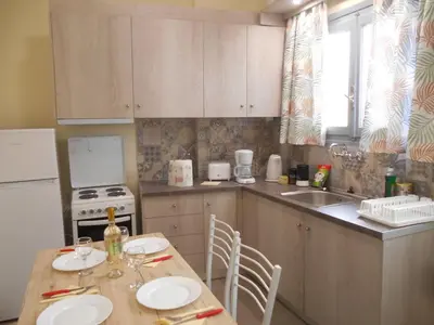 a kitchen with a table with chairs and a sink at Koukaki-Acropolis roomy with a private veranda apt. in Athens