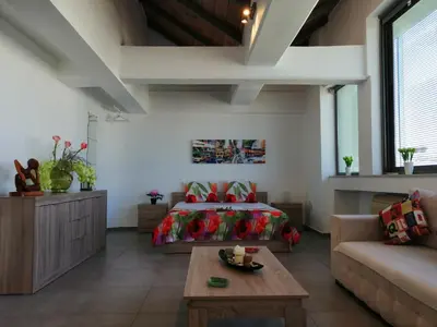 a bedroom with a bed and a couch and a table at Spacious & Modern Studio Apartment Near the Airport in Glyka Nera