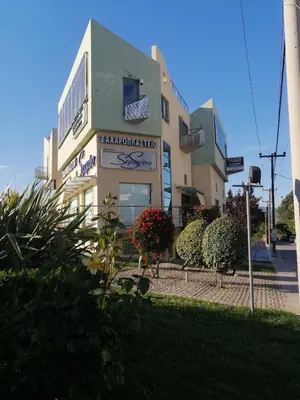 a building with plants in front of it at Spacious & Modern Studio Apartment Near the Airport in Glyka Nera