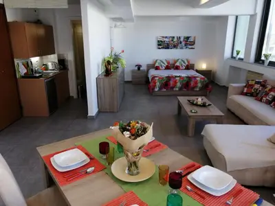 a living room with a couch and a table in a room at Spacious & Modern Studio Apartment Near the Airport in Glyka Nera