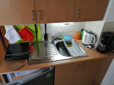 a kitchen counter with a sink and a drying rack at Spacious & Modern Studio Apartment Near the Airport in Glyka Nera