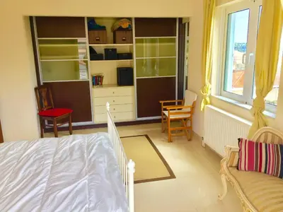 a bedroom with a bed and chairs and a window at Modern apartment near Athens&Coast in Keratea