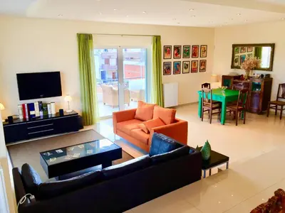a living room with a couch and a table at Modern apartment near Athens&Coast in Keratea