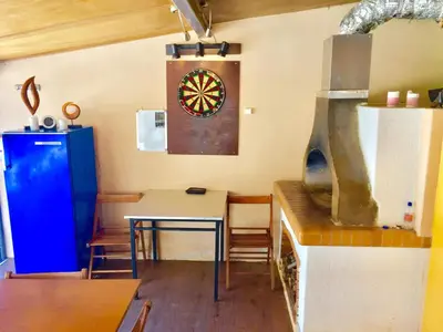 a kitchen with a table and a dartboard on the wall at Modern apartment near Athens&Coast in Keratea