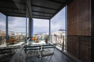 a balcony with a table and chairs with a view at Athens BlueBuilding in Athens