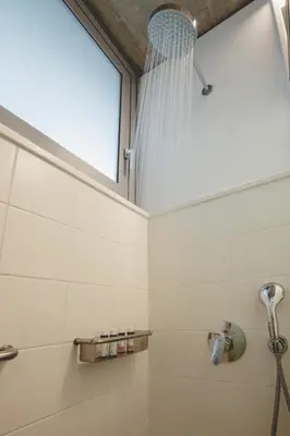 a bathroom with a shower and a window at Athens BlueBuilding in Athens