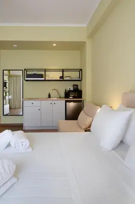 a bedroom with a large white bed and a kitchen at ATHENS STORIES in Athens