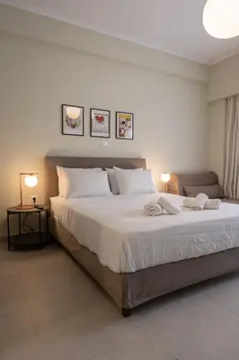a bedroom with a large white bed with two lamps at ATHENS STORIES in Athens