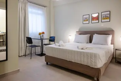 a bedroom with a bed and a table with chairs at ATHENS STORIES in Athens