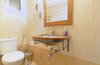 a bathroom with a sink and a toilet and a mirror at Courtyard Apt - Central Athens in Athens