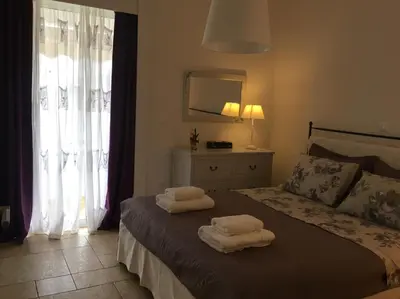 a bedroom with a bed with two towels on it at Bay watch Apartment close to the airport at PORTO RAFTI in Porto Rafti