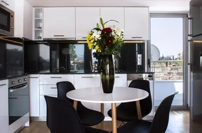 a vase of flowers on a table in a kitchen at Acropolis View Rooftop Apartment Athens in Athens