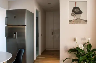 a kitchen with a stainless steel refrigerator and a table at Acropolis View Rooftop Apartment Athens in Athens
