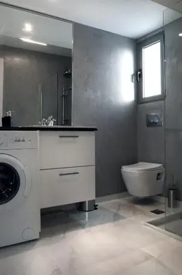 a bathroom with a washing machine and a toilet at Acropolis View Rooftop Apartment Athens in Athens