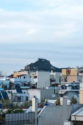 a city with buildings and a hill in the background at Acropolis View Rooftop Apartment Athens in Athens