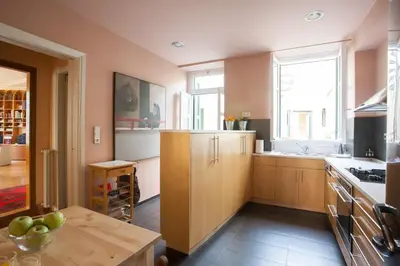 a kitchen with wooden cabinets and a table in it at House at the Foothills of Acropolis in Athens