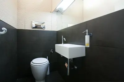 a bathroom with a white toilet and a sink at House at the Foothills of Acropolis in Athens
