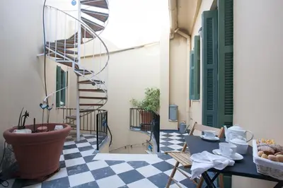 a room with a checkered floor and a spiral staircase at House at the Foothills of Acropolis in Athens