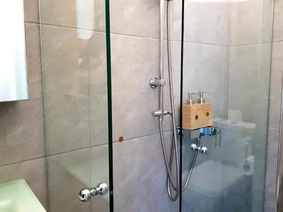 a shower in a bathroom with a glass door at Boutique Athensairport Apartments in Markopoulo