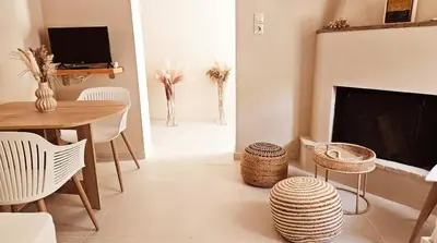 a living room with a table and a fireplace at Boutique Athensairport Apartments in Markopoulo