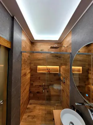 a bathroom with a shower with a sink and a mirror at Boutique Athensairport Apartments in Markopoulo