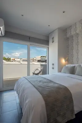 a bedroom with a large bed and a large window at 12 Keys Athens Apartments in Athens