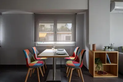 a dining room with a table and chairs and a window at 12 Keys Athens Apartments in Athens