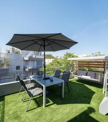 a patio with a table and chairs and an umbrella at 12 Keys Athens Apartments in Athens