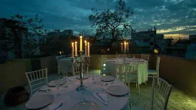 a table with candles and plates and chairs on a balcony at ATHENS City Center Historical Area in Athens