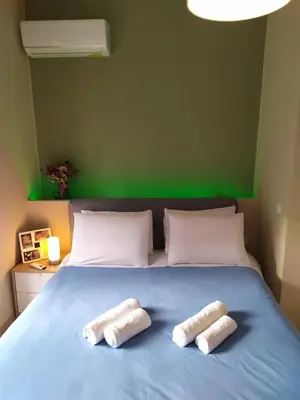two towels on a blue bed with a green wall at Renovated apartment close to Exarchia square in Athens