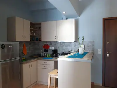 a kitchen with white cabinets and a counter top at Renovated apartment close to Exarchia square in Athens