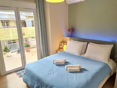 a bedroom with a blue bed with two towels on it at Renovated apartment close to Exarchia square in Athens