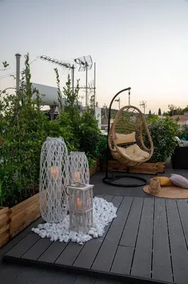 a patio with a table and a chair on a deck at Plaka Arch Suites in Athens