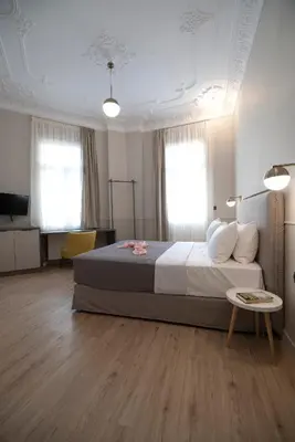 a bedroom with a large bed and a table at Plaka Arch Suites in Athens