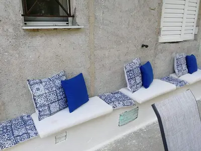 a bench with blue and white pillows on it at Lemontree in Athens