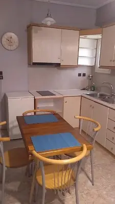 a kitchen with a wooden table and chairs in it at Lemontree in Athens