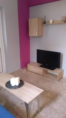 a living room with a table and a flat screen tv at Lemontree in Athens