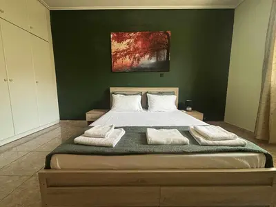 a bedroom with a large bed with two towels on it at Lemontree in Athens