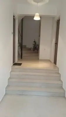 a hallway with white stairs and a light fixture at Lemontree in Athens