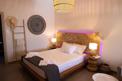a bedroom with a large bed with two lamps at New seafront studio in Anavissos