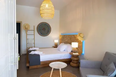 a bedroom with a bed and a chair and a couch at New seafront studio in Anavissos