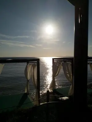 a view of the ocean from a house with the sun at New seafront studio in Anavissos