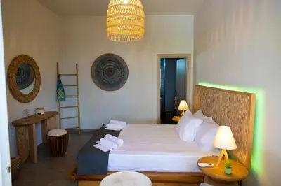 a bedroom with a bed with white sheets and a lamp at New seafront studio in Anavissos
