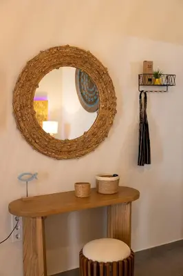 a mirror on a wall with a table and a stool at New seafront studio in Anavissos