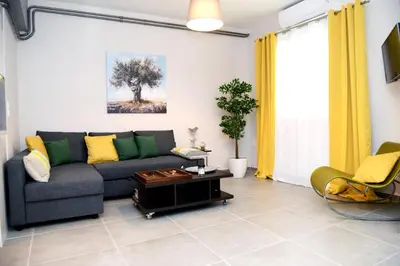 a living room with a couch and a table at Olive Tree Deluxe Apt under Acropolis in Athens