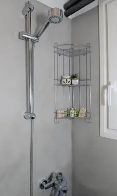 a shower with a metal shelf above a sink at Olive Tree Deluxe Apt under Acropolis in Athens