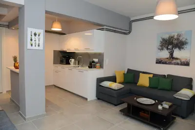 a living room with a couch and a kitchen at Olive Tree Deluxe Apt under Acropolis in Athens