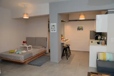 a living room with a bed and a kitchen at Olive Tree Deluxe Apt under Acropolis in Athens